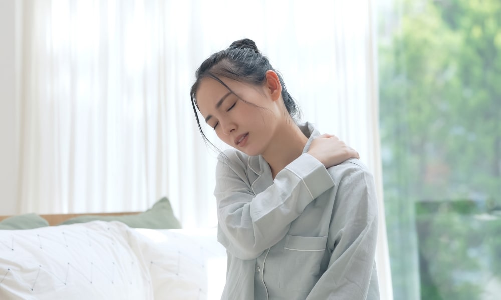 肩こりで辛そうな女性