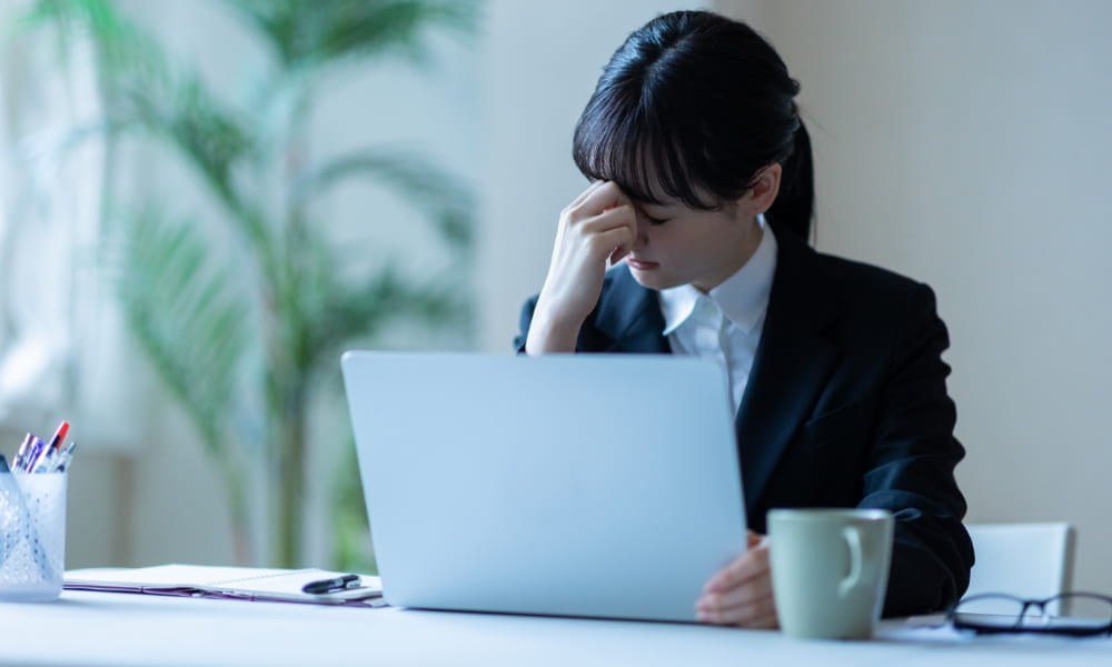 デスクワークで眼精疲労の女性
